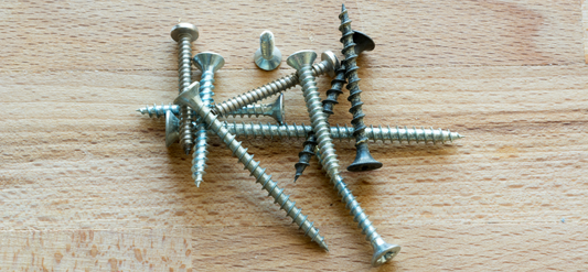 Pile of screws on board of wood