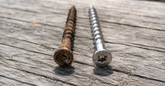 Rusted coated deck screw beside a clean Eagle Claw stainless steel deck screw, the best Deck Mate alternative