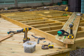 Wooden deck construction with tools and materials on a wooden platform
