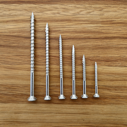 stainless steel eagle claw screws that come in the free sample pack on a wooden surface