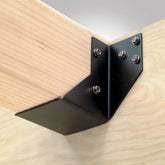 Black metal corner brace with screws on a wooden beam
