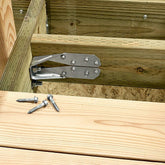 Metal bracket attached to wooden beams with screws on a wooden surface